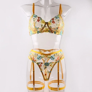 Detail of yellow mesh lingerie set with colorful floral embroidery and satin garter straps