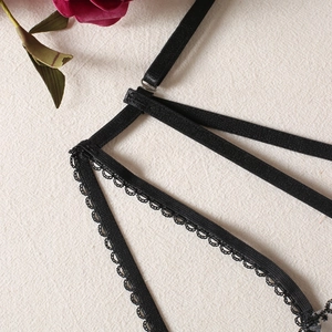 Detail of black elastic lingerie straps with delicate wavy lace and silver metal buckle