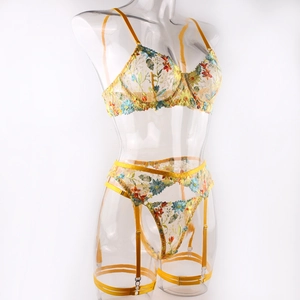 Detail of yellow floral embroidery on sheer mesh lingerie set with garter straps