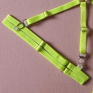 Detailed view of adjustable neon green lace garter strap with metal buckles and clips
