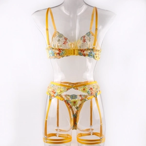 Detail of yellow floral embroidery on sheer mesh bra, garter belt and thong set