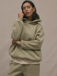 Detail of sage green oversized hoodie featuring dropped shoulders and ribbed cuffs