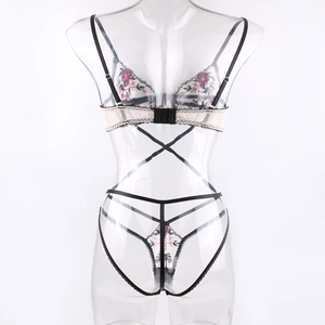 Detail of floral embroidery on lace lingerie set with cross-strap design and mesh fabric