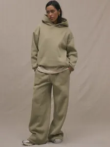Detail of sage green oversized hoodie and straight leg joggers in heavy knit fabric