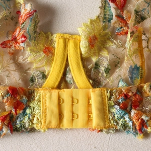 Detail of multi-color floral embroidery and hook-and-eye closure on yellow lingerie back
