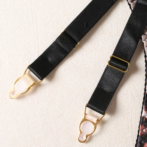 Detailed macro view of black elastic garter straps with gold adjusters and leopard print