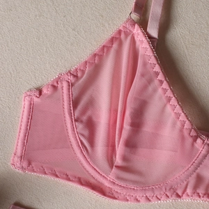 Detailed macro shot of pink mesh fabric with underwire and fine triangular stitching