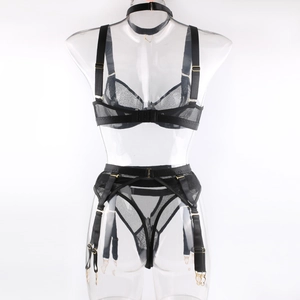Detail of black mesh lingerie set featuring garter belt and gold hardware on a mannequin