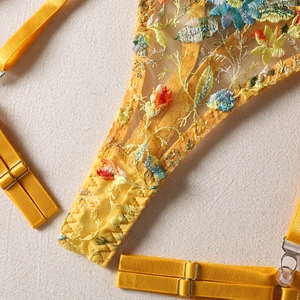 Detailed view of yellow lace lingerie set with colorful floral embroidery and adjustable straps