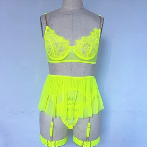 Detail of neon yellow lace bra with gold metal chains and sheer mesh skirt details