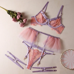 Vue détaillée à plat d'un ensemble de lingerie quatre pièces en dentelle rose et lilas