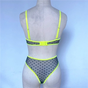 Detail view of the fluorescent yellow back buckle and black polka dot mesh on the bra