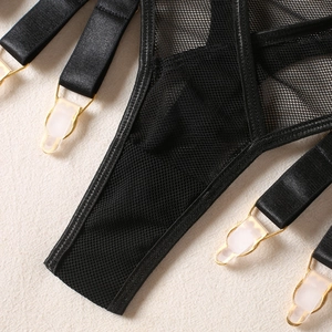 Detail of black mesh garter with golden metal clips and glossy satin strap accents