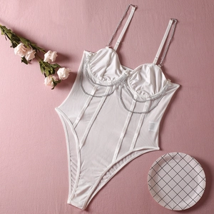 Détail d'un body blanc en mesh avec chaînes métalliques argentées et finitions en satin