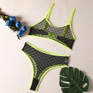 Detailed flat lay of neon green mesh lingerie set with black polka dots and mesh texture