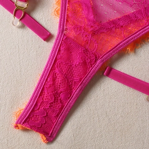 Close-up of rose red lace with orange eyelash trim and adjustable garter strap detail