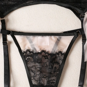 Detail of floral black lace stitching with pink mesh and adjustable straps on lingerie