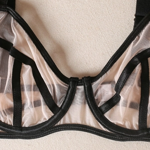 Detail of mesh bra with black strap framework and breathable sheer fabric texture