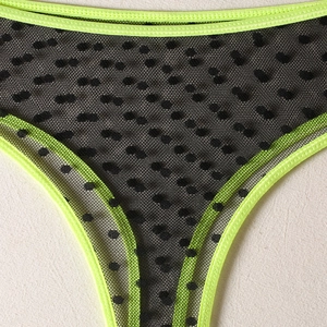 Detail of neon green elastic bands and black polka dot mesh on these sexy panties