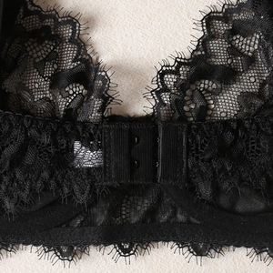 Detail of black eyelash lace lingerie featuring intricate floral patterns and back hook closure