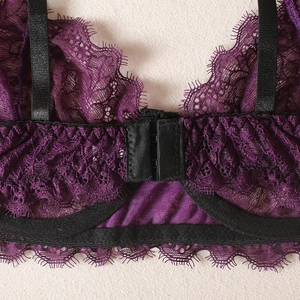 Detail of dark purple lace lingerie with eyelash edges and front closure buckle