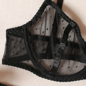 Detail of black polka dot mesh bra showing delicate lace trim and sheer fabric textures