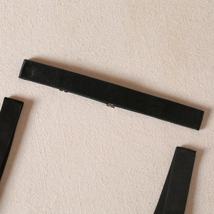 Close-up of black elastic lingerie straps with smooth adjustable silver metal buckles