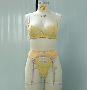 Détail de l'ensemble de lingerie en dentelle jaune avec nœuds violets et motifs floraux