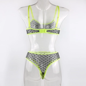 Detailed view of neon green sheer mesh lingerie set with black polka dots on display