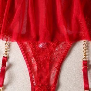 Detail of red floral lace lingerie with elegant gold metal chains and sheer mesh fabric
