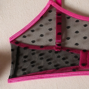Detail of pink and black polka dot mesh bra with fine stitching and breathable fabric