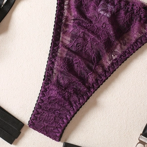 Detail of purple floral embroidery lace with black elastic straps and silver buckles