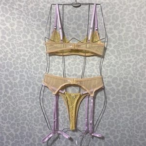 Détails de l'ensemble lingerie en dentelle jaune avec bretelles lilas et nœuds