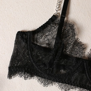 Close-up of black eyelash lace bra with elegant silver metal chain shoulder strap