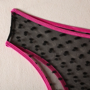 Detail of sheer black mesh lingerie with flocking polka dots and pink satin trim