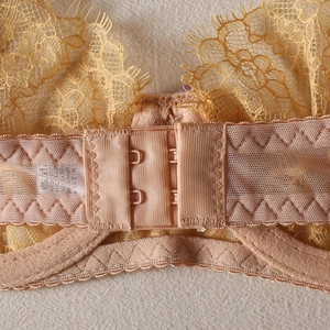 Détail de la fermeture à double agrafe et dentelle à cils sur ensemble lingerie jaune