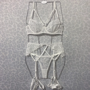 Detail of white floral lace lingerie set with strappy harness and adjustable garter belt