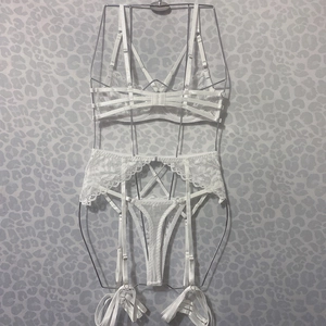 Detailed view of white lace lingerie set featuring adjustable straps and sheer floral patterns