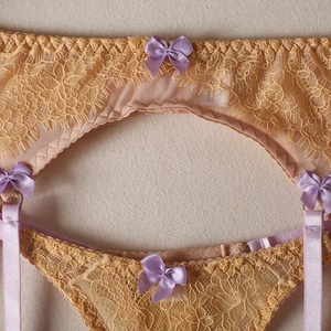 Détails de lingerie en dentelle jaune avec nœuds en satin lilas et porte-jarretelles