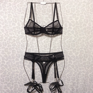 Detailed view of black polka dot mesh lingerie set with lace garter belt and thong