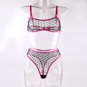 Detail of black polka dot mesh lingerie set with vibrant pink elastic piping and straps