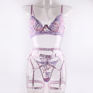 Détail de la broderie florale lavande sur un ensemble de lingerie trois pièces avec anneaux