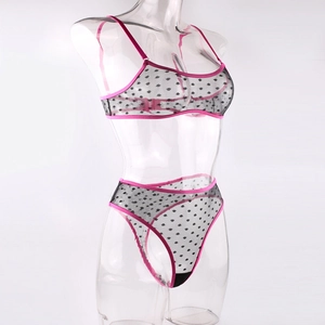 Detail of polka dot mesh lingerie set with vibrant fuchsia straps on a mannequin