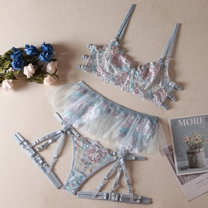 Flat lay of light blue lingerie set with floral embroidery and mesh garter detail