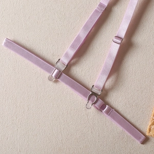 Détail d'une bretelle élastique réglable rose pâle avec boucle en métal pour lingerie