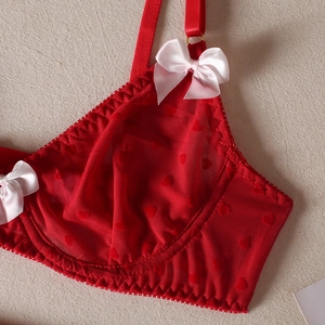 Close-up of red heart flocked mesh bra with delicate white satin bow on shoulder strap