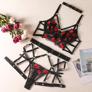 Vue à plat d'un ensemble de lingerie en dentelle noire avec broderie de roses rouges