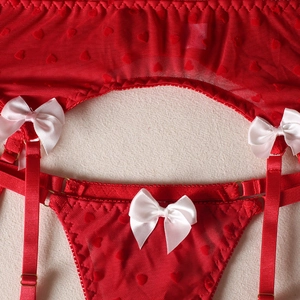 Macro shot of red heart mesh lingerie with satin bows and adjustable gold buckles