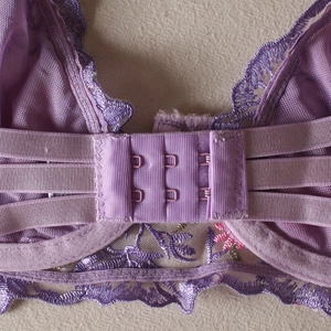 Détail macro de la fermeture arrière du soutien-gorge en dentelle violette brodée