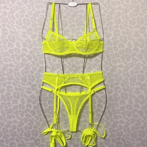 Detail of neon yellow mesh lingerie set with polka dots and garter belt on wire hanger